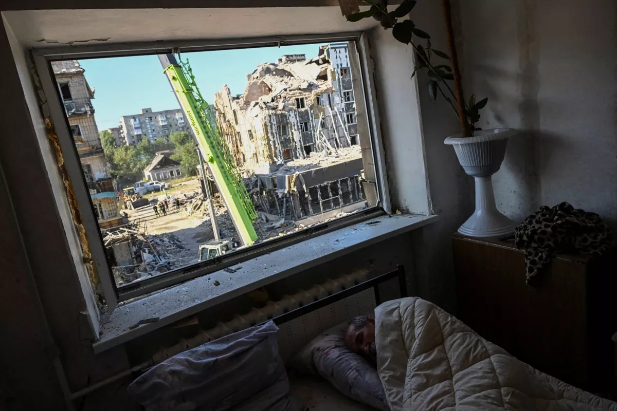Житель Покровска пытается уснуть внутри поврежденного жилого дома во время утренних обстрелов. 8 августа / Viacheslav Ratynskyi / Reuters / The Guardian